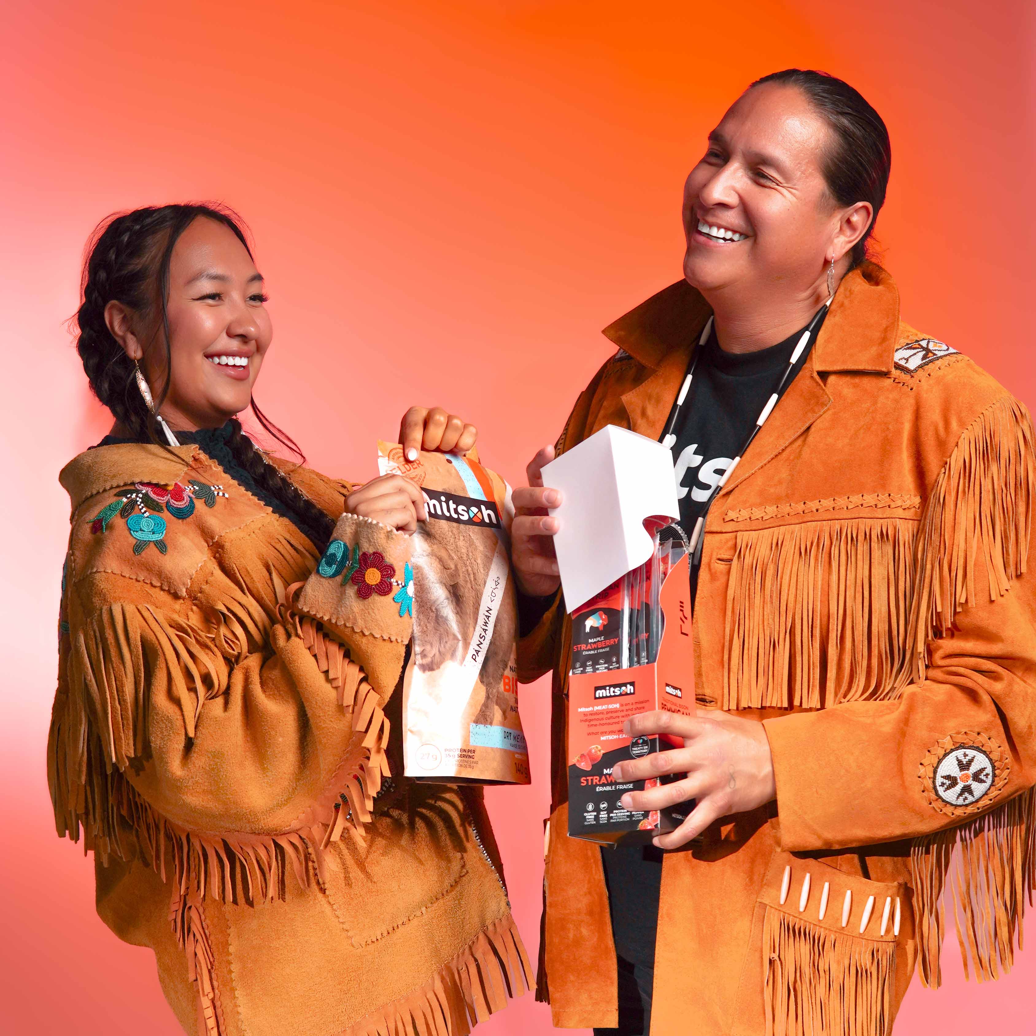 Mitsoh founder Ian Gladue wearing traditional Indigenous clothing while sharing Mitsoh pemmican and dry bison meat products