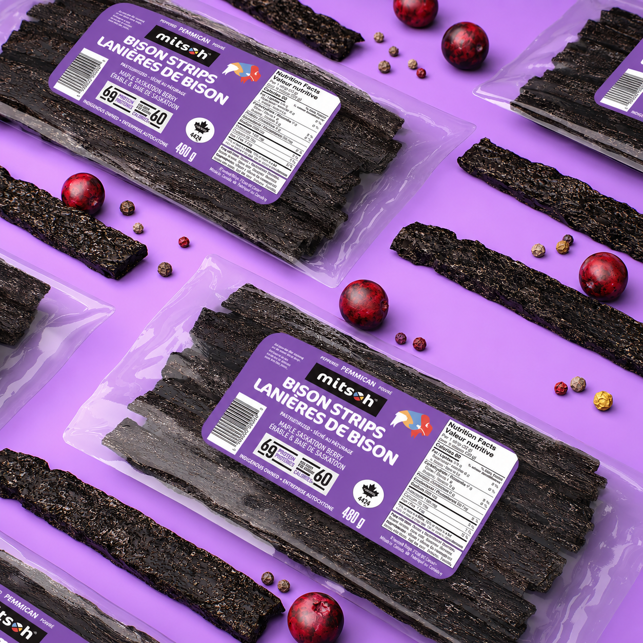 Peppered Saskatoon Berry Bison Pemmican bulk packs arranged with berries, pepper and pemmican strips