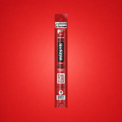 Single Spicy Original Grass-Fed Beef Stick on a red background
